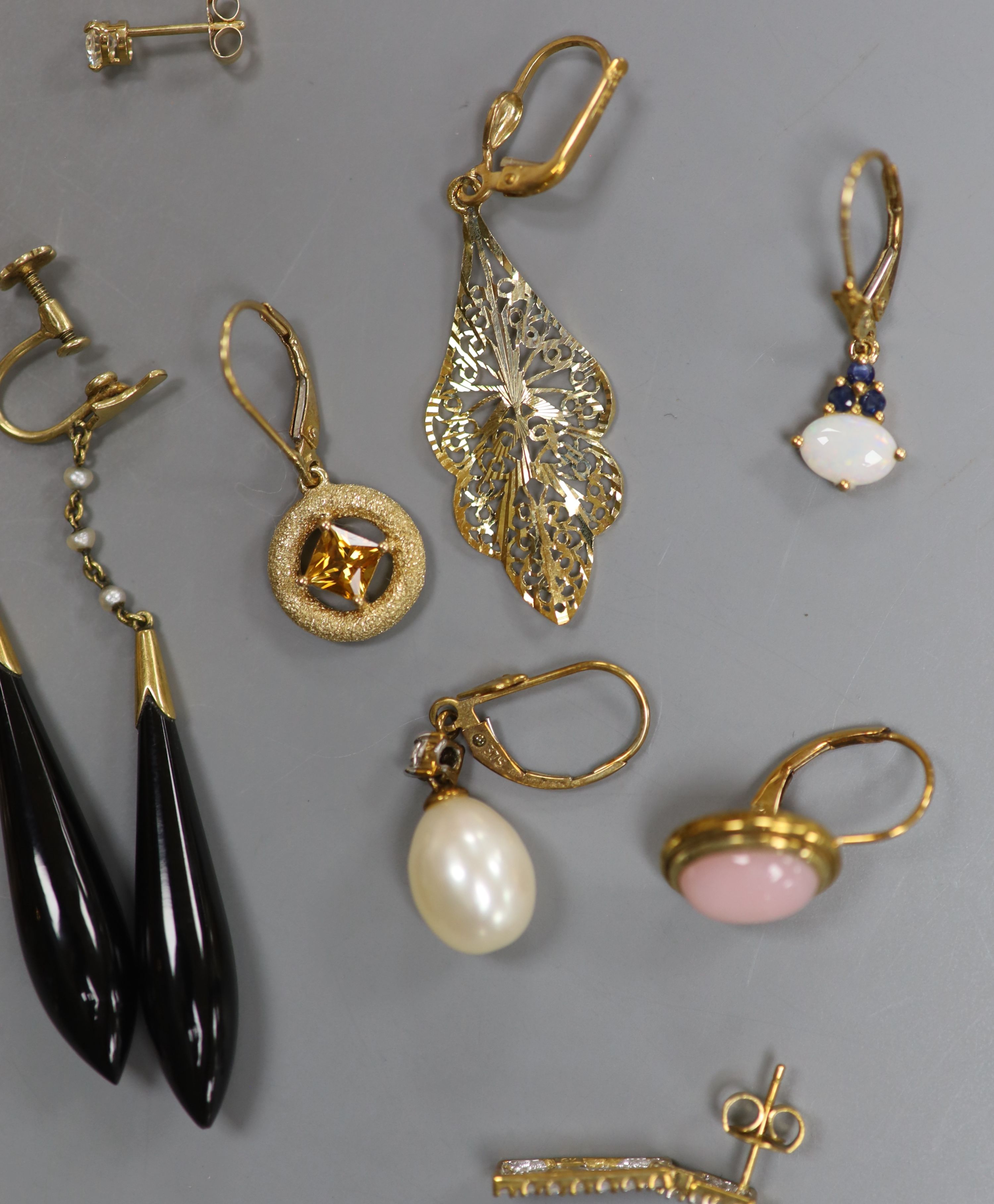 Seven pairs of hallmarked gold earrings, variously set, a single 14K marked stud earring, a pair of drop earrings and a yellow metal ring